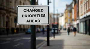 street sign that says changed priorities ahead on a busy street of LA